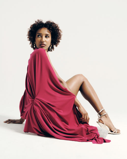 Model wearing the Signature Draped Long Top in fuchsia pink, featuring a draped silhouette and open back. Made-to-order in the UK.